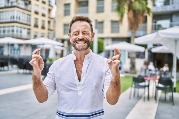 Middle Age Man Outdoor City Gesturing Finger Crossed Smiling Hope — Fotografia de Stock