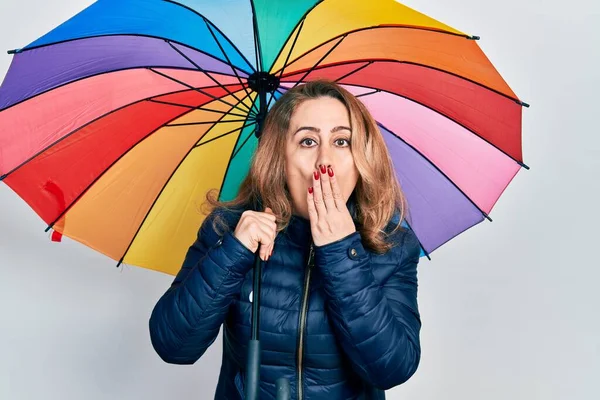 中世の白人女性は手で口を覆い ショックを受け 間違いを恐れてカラフルな傘を持っていた 驚きの表情 — ストック写真