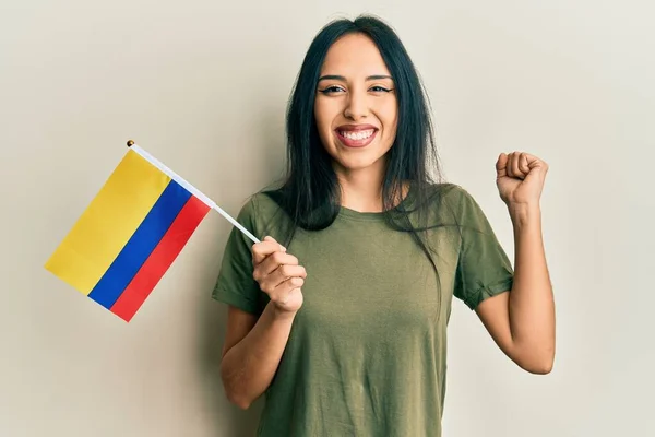 Młoda Latynoska Dziewczyna Trzyma Flagę Kolumbii Krzycząc Dumny Świętując Zwycięstwo — Zdjęcie stockowe