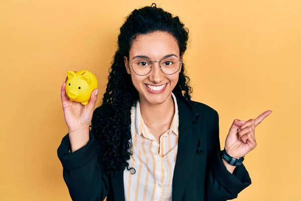 Young Hispanic Woman Curly Hair Holding Piggy Bank Smiling Happy — Stockfoto