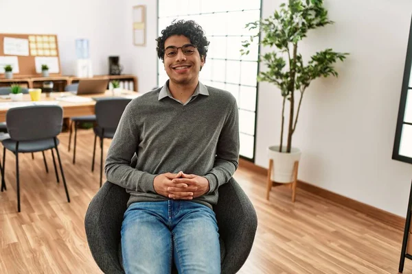 若いヒスパニック系の実業家がオフィスで椅子に座って幸せな笑顔 — ストック写真