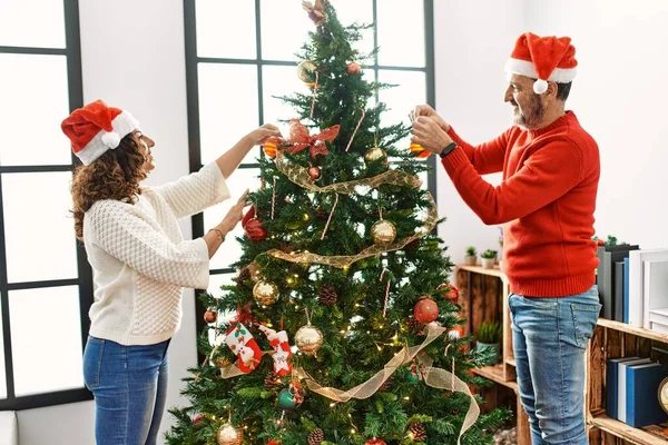 Pareja Hispana Mediana Edad Sonriendo Feliz Decorando Árbol Navidad Casa —  Fotos de Stock