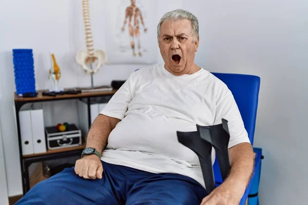 Starší Běloch Fyzioterapeutické Klinice Držel Berle Rozzlobený Šílený Jekot Frustrovaný — Stock fotografie
