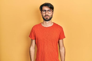 Günlük kıyafetler ve gözlük takan genç İspanyol adam yüzünde ciddi bir ifadeyle rahatladı. Basit ve doğal bir şekilde kameraya bakıyorsun.. 