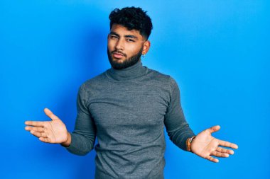 Balıkçı yaka kazak giyen sakallı bir Arap 'ın kolları açık ve hiçbir fikri yok.. 