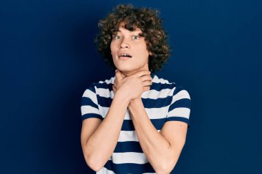 Handsome young man wearing casual striped t shirt shouting and suffocate because painful strangle. health problem. asphyxiate and suicide concept. 