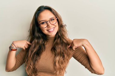 Gündelik kıyafetler ve gözlük takan, kendine güvenen, gülümseyen, kendini gururlu ve mutlu gösteren genç İspanyol kız.. 