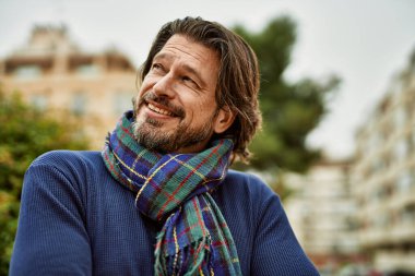 Kasabada gülümseyen orta yaşlı yakışıklı bir adam.