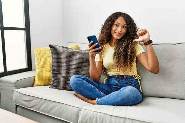 Beautiful Hispanic Woman Sitting Sofa Home Using Smartphone Looking Confident — Fotografia de Stock