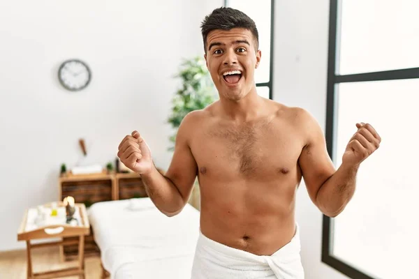 Young Hispanic Man Standing Shirtless Spa Center Celebrating Surprised Amazed — Zdjęcie stockowe