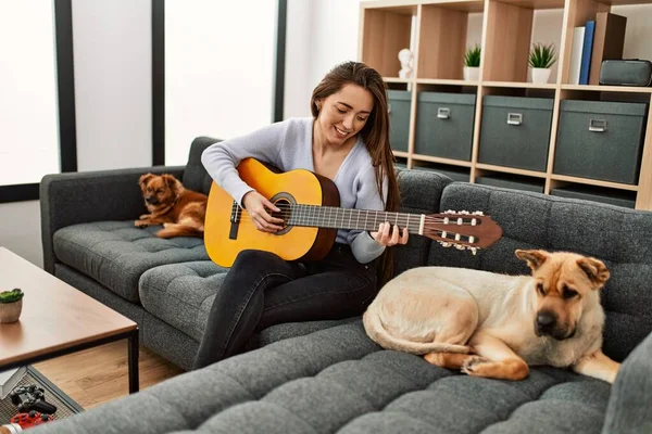 Jovem Hispânica Tocando Guitarra Clássica Sentada Sofá Com Cães Casa — Fotografia de Stock