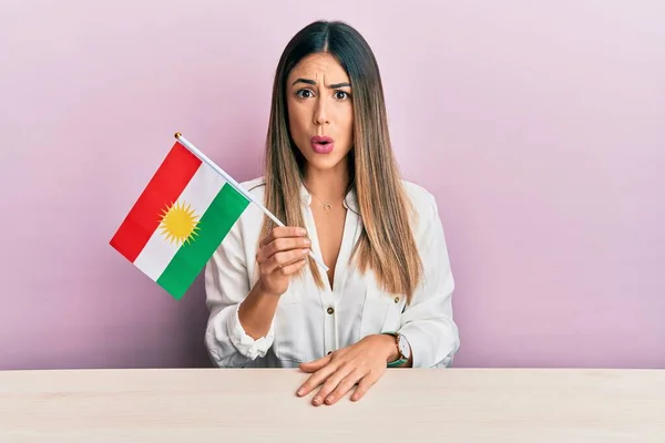 Fiatal Spanyol Kezében Kurdisztán Zászló Asztalon Ijedt Csodálkozott Nyitott Szájjal — Stock Fotó
