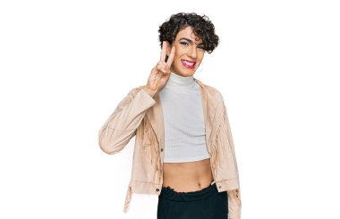 Handsome man wearing make up and woman clothes showing and pointing up with fingers number two while smiling confident and happy. 