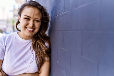 Çekici ve güzel İspanyol kadın güneşli bir havada mutlu gülümsüyor. Güzel esmer kız pozitif gülüşü olan Şehre kendinden emin bakan