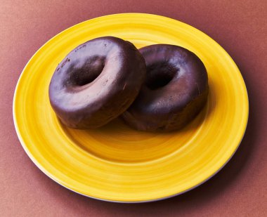  Kahverengi arka planda iki çikolatalı çörek tabağı.