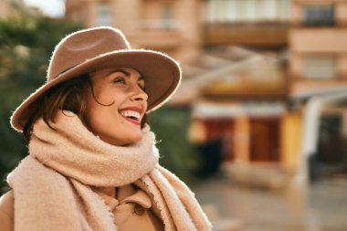 Şık giyinen genç İspanyol kadın şehirde dikiliyor..