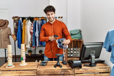 Genç İspanyol esnaf mağazada çalışırken gülümsüyor..