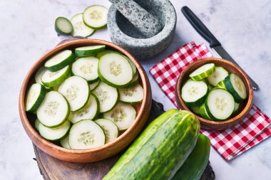  Mermer bir yüzeyde bir kase salatalık dilimi