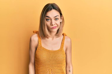 Sıradan sarı tişört giyen, kuşkucu ve gergin genç, beyaz bir kadın sorun yüzünden surat asıyor. negatif kişi. 