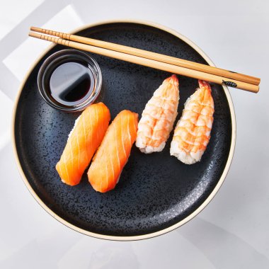  İki tabak karides nigiri sushi ve beyaz arka planda iki salomon nigiri suşi.