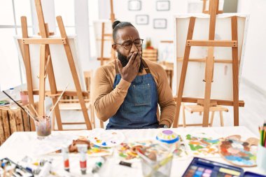 African american artist man at art studio bored yawning tired covering mouth with hand. restless and sleepiness. 