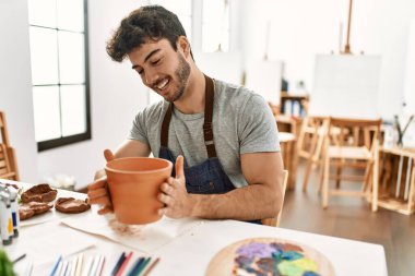 Genç İspanyol ressam gülümsüyor. Sanat stüdyosunda mutlu model çanak çömleği..