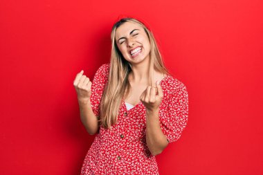 Güzel İspanyol kadın, yaz elbisesi giyiyor. Çok mutlu ve heyecanlı. Kazanan jestler yapıyor, kollarını kaldırıyor, gülümsüyor ve başarı için bağırıyor. kutlama konsepti. 