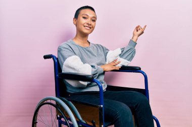 Tekerlekli sandalyede oturan, yüzünde kocaman bir gülümseme olan, eli ve parmağı kameraya bakan güzel İspanyol kadın.. 