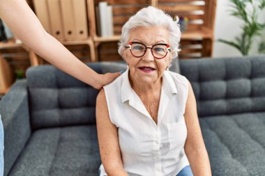 Psikoloji merkezinde psikolog danışmanı olan yaşlı, kır saçlı bir kadın.