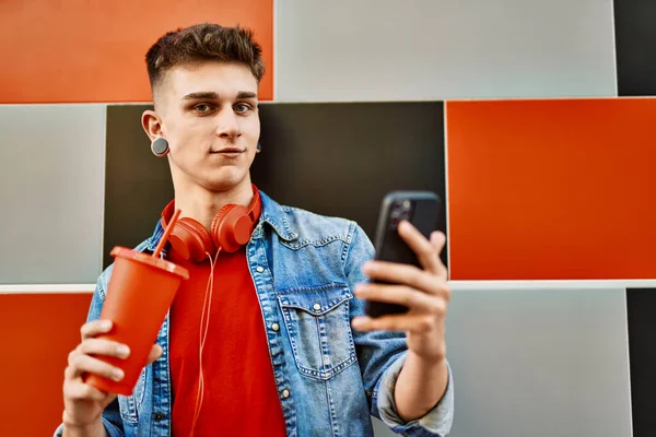 Jovem Caucasiano Cara Bebendo Refrigerante Usando Smartphone Encostado Parede — Fotografia de Stock