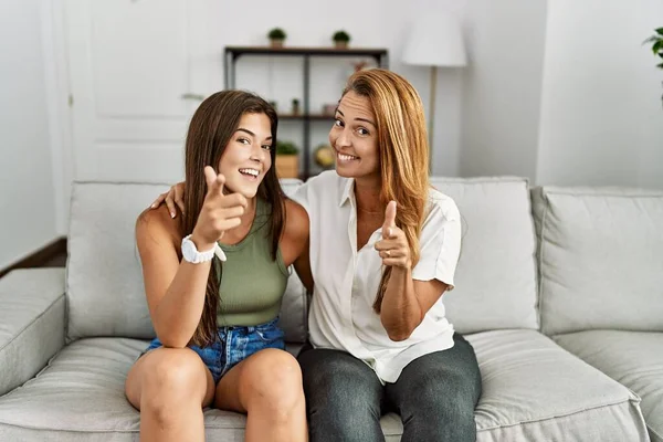 Mother Daughter Together Sitting Sofa Home Pointing Fingers Camera Happy — Stockfoto