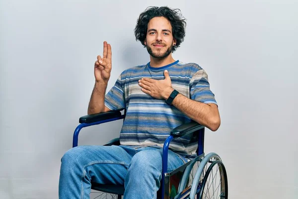 Tekerlekli Sandalyede Oturan Yakışıklı Gülümseyen Elleri Göğsünde Parmakları Havada Yemin — Stok fotoğraf