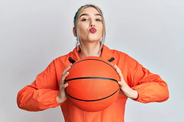 年轻的现代女孩拿着篮球 看着镜头 飞吻着可爱而性感 爱的表达 — 图库照片