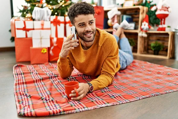 Young Arab Man Talking Smartphone Drinking Coffee Lying Floor Christmas — Foto de Stock