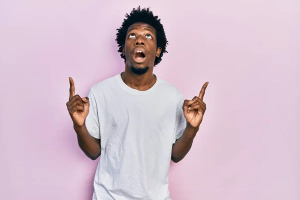 Joven Afroamericano Vestido Con Camiseta Blanca Casual Asombrado Sorprendido Mirando —  Fotos de Stock