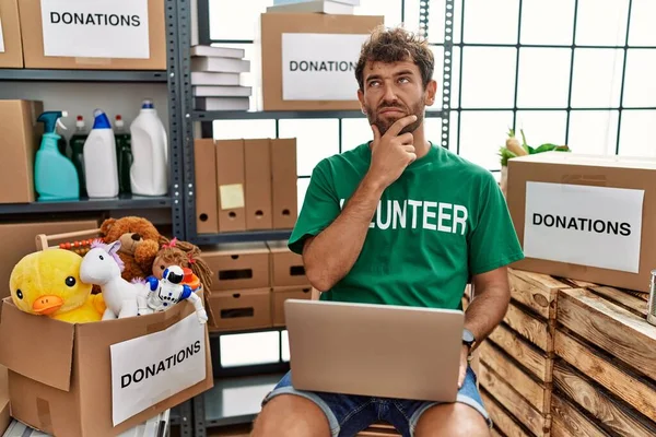 Young Handsome Man Wearing Volunteer Shirt Using Laptop Thinking Worried — ストック写真