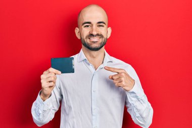 Genç kel adam hafızasını koruyor. Gülümsüyor, mutlu bir şekilde eli ve parmağı işaret ediyor. 