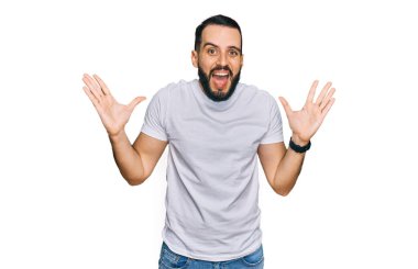 Sakallı genç adam, sıradan beyaz tişörtler giyip çılgınlığı kutluyor ve başarıyı kolları açık, gözleri açık heyecanla haykırarak kutluyor. Kazanan konsept 