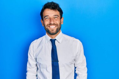 Handsome man with beard wearing business shirt and tie with a happy and cool smile on face. lucky person. 