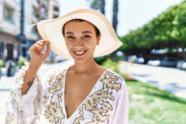 Sokakta kendinden emin gülümseyen genç İspanyol kadın.