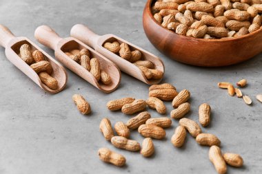 Beton yüzeyde fıstıklı ahşap kaşıklar.