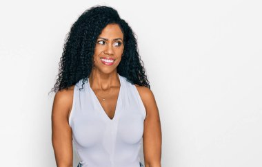 Orta yaşlı Afro-Amerikalı kadın, sıradan giyinmiş, kolsuz tişörtlü, gülümseyerek yan tarafa bakıyor ve şöyle düşünüyor:. 