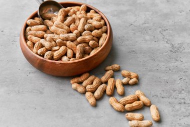 Beton bir yüzeyde kasede bir avuç fıstık.