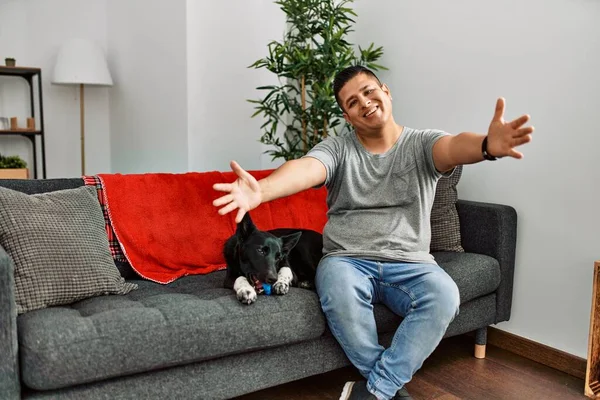 Jovem Latino Cachorro Sentado Sofá Casa Olhando Para Câmera Sorrindo — Fotografia de Stock