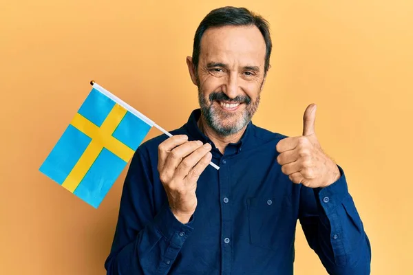 Homem Hispânico Meia Idade Segurando Bandeira Sueca Sorrindo Feliz Positivo — Fotografia de Stock