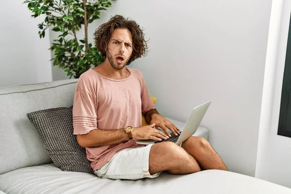 Young Hispanic Man Sitting Sofa Home Using Laptop Shock Face — Stock Photo, Image
