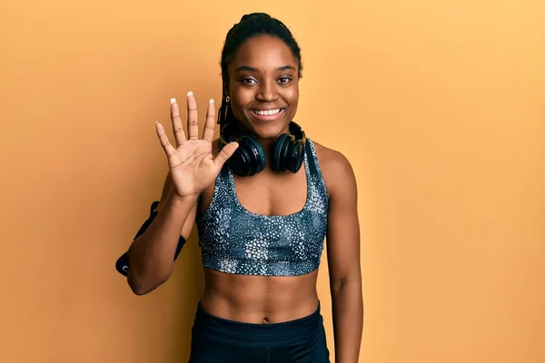 Mujer Afroamericana Con Cabello Trenzado Usando Ropa Deportiva Brazalete Mostrando —  Fotos de Stock