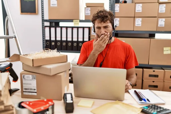 Young Hispanic Call Center Agent Man Working Warehouse Bored Yawning — стоковое фото