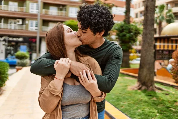 站在城中亲吻拥抱的跨种族年轻夫妇 — 图库照片