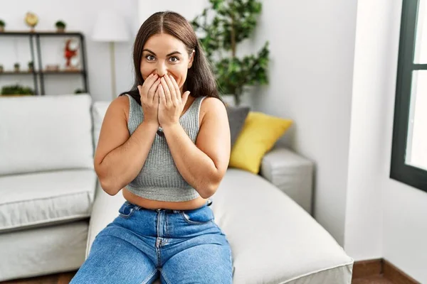 Young Brunette Woman Sitting Sofa Home Laughing Embarrassed Giggle Covering — Stock Photo, Image